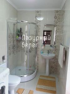a bathroom with a shower and a toilet and a sink at Центр Отдыха Лазурный берег in Chok-Tal