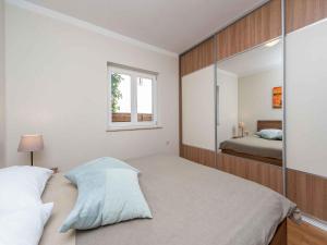 a bedroom with a bed with a large mirror at Holiday home Kozino/Zadar Riviera 33795 in Kožino