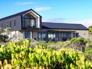 a house with a black roof on top of a hill at Seas the Day Romansbaai in Gansbaai