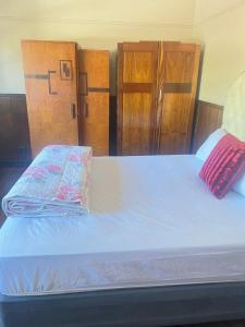 a bed in a room with wooden cabinets at tripple s guest house in Cape Town