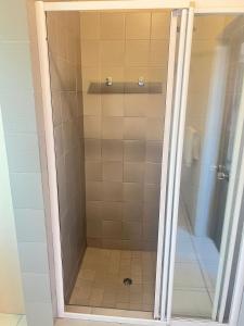 a shower with a glass door in a bathroom at tripple s guest house in Cape Town