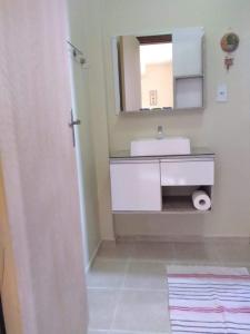 uma casa de banho com um lavatório branco e um espelho. em Pousada Guesthouse em Timbó