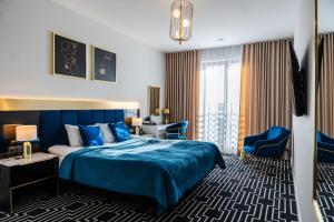 a hotel room with a blue bed and a desk at MODERNO hotel Garwolin 