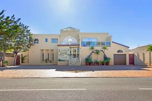 a large white house with a driveway at Kwantu Guesthouse 1 in Cape Town