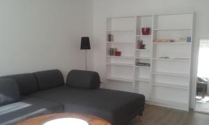 ein Wohnzimmer mit einem Sofa und weißen Regalen in der Unterkunft Ferienwohnung "Rückenwind" in Norderney