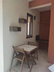 una mesa de madera y 2 sillas en una habitación en Pousada Guesthouse en Timbó