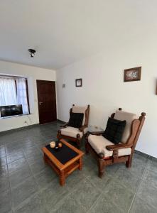 uma sala de estar com duas cadeiras e uma mesa de centro em Duplex 2 - Rama Caida em Pinamar