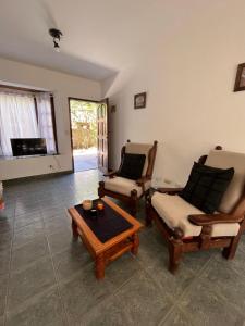 uma sala de estar com duas cadeiras e uma mesa de centro em Duplex 2 - Rama Caida em Pinamar