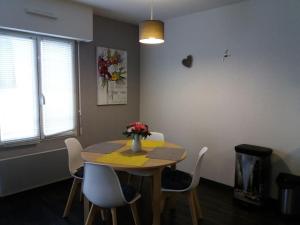a dining room table with chairs and a vase of flowers on it at Appartement au centre-ville Concarneau in Concarneau