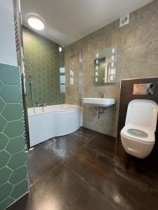 a bathroom with a tub and a toilet and a sink at Amber Lights Coastal Getaway, Greatstone in Greatstone +18 photos