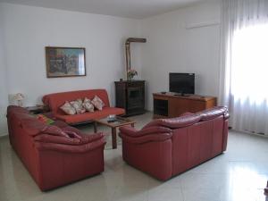 un soggiorno con 2 divani rossi e una TV di la casa di Emilia a Nocera Inferiore