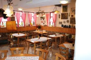 ein Restaurant mit Holztischen, Stühlen und Fenstern in der Unterkunft Gasthaus Zur Weintraube in Bad Langensalza