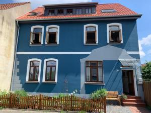 una casa azul con techo rojo en Gästehaus EinsA, en Celle