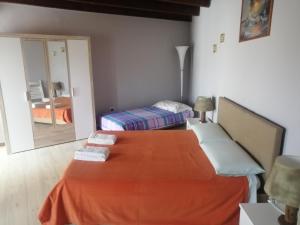 a bedroom with a orange bed and a mirror at Domo Serra E Mesu in Magomadas