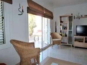 een woonkamer met rieten stoelen en een televisie bij Centrally located apartment with free A/C + WIFI in L'Estartit