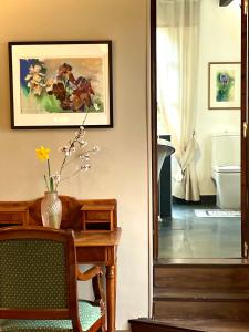 EVERGREEN GuestHouse في فيرنون: غرفة مع طاولة و مزهرية عليها زهور
