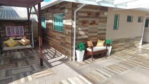 an outdoor patio with a couch and two plants at Uma agradável morada para descansar com a família ! in Governador Celso Ramos