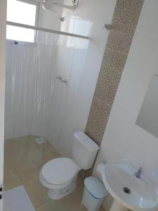 a white bathroom with a toilet and a sink at Pousada São Francisco PETAR in Iporanga