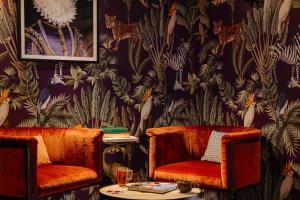 - deux chaises et une table dans une chambre avec papier peint dans l'établissement The ED Amsterdam, à Amsterdam