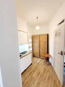 a room with a kitchen with a wooden floor at Apartamenty Dolce Vita in Ostrowo