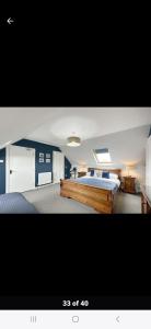 1 dormitorio con 1 cama grande y paredes azules en Fort William loft on shore front with amazing views en Caol