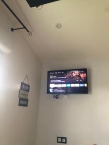 TV de pantalla plana en la pared de una habitación en Le Petit Colombes en Colombes