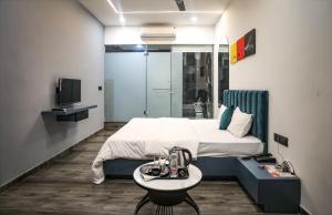 een slaapkamer met een bed en een tafel en een televisie bij HOTEL THE PARKER INN By KBNT GROUP in Surat