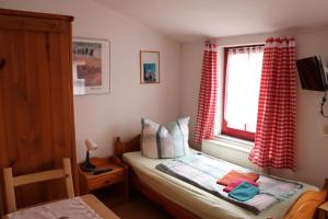ein kleines Schlafzimmer mit einem Bett und einem Fenster in der Unterkunft Gasthaus Zur Weintraube in Bad Langensalza