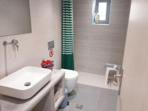 un bagno bianco con lavandino e WC di Bright town house a Kampos Paros Altre 25 foto