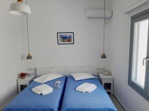 una camera da letto con due letti blu e una finestra di Bright town house a Kampos Paros