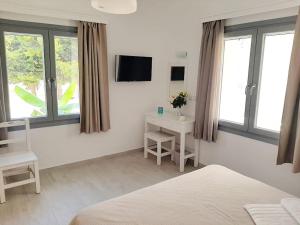 una camera da letto con un letto, una scrivania e finestre di Bright town house a Kampos Paros