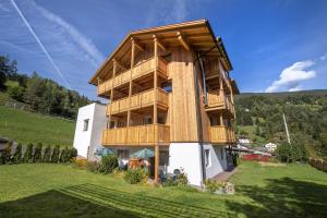a building with a balcony on the side of a hill at Apartments Bea in Ortisei