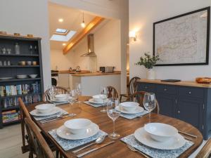 a dining room with a table with plates and glasses at The Cook House in Devizes