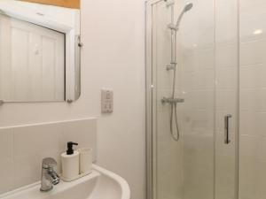 a white bathroom with a shower and a sink at The Cook House in Devizes