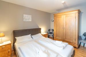 een slaapkamer met een bed en een houten kast bij Bildstöckle in Sonthofen