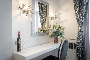 una mesa blanca con una botella de vino y una copa en Starlight Luxury Rooms en Split