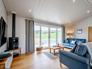 a living room with a blue couch and a tv at 2 Bed in Castle Douglas 77838 in Auchencairn