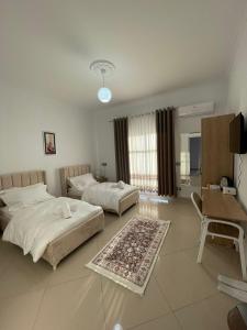 a bedroom with two beds and a table and a desk at Harmony Villa Berat in Berat