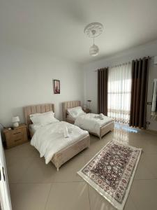 a bedroom with two beds and a rug at Harmony Villa Berat in Berat