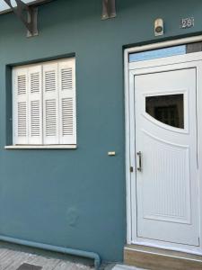 a blue wall with a white door and a window at Old Town Home Ioannina in Ioannina