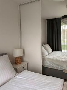 a small bedroom with two beds and a mirror at Rest In Sanok Apartment in Sanok