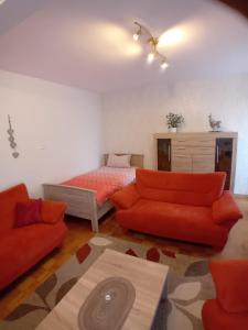 a living room with a bed and orange furniture at Ferienwohnung am Dorfplatz in Waldkappel