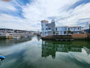 a building sitting on the water next to a river at Quay Five on the Waterfront in Knysna