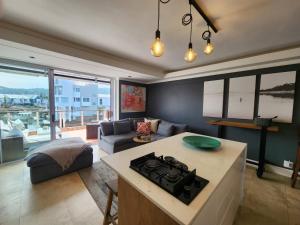 a kitchen and living room with a couch and a stove at Quay Five on the Waterfront in Knysna