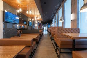 a dining room with wooden tables and leather chairs at Sandman Signature Newcastle Hotel in Newcastle upon Tyne