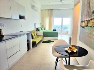 a kitchen and living room with a couch and a table at Ocean Breeze Residence- Negombo in Negombo