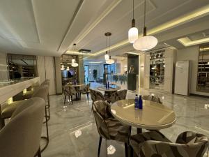 Atar Airport Hotel في Arnavutköy: مطعم فيه طاولات وكراسي في الغرفة
