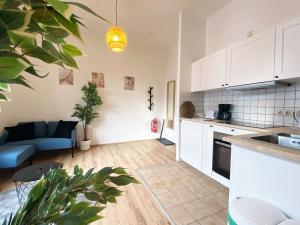cocina y sala de estar con armarios blancos y sofá azul en Nice Apartment in Essen, en Essen