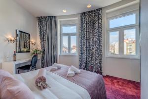 1 dormitorio con 1 cama grande y 2 ventanas en Starlight Luxury Rooms en Split