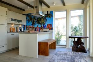 a kitchen with white cabinets and a counter with a bench at Typ A Ferienhaus - Kailua in Pelzerhaken